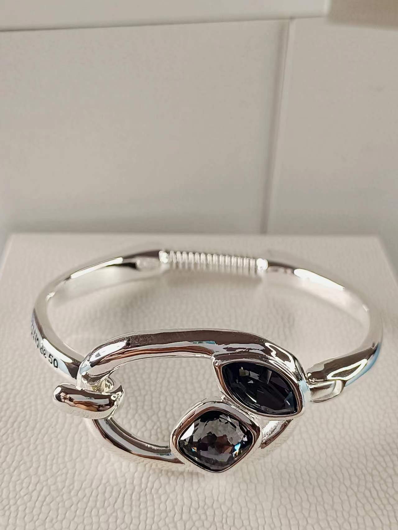 Silver bracelet with silver and greenish gray crystals